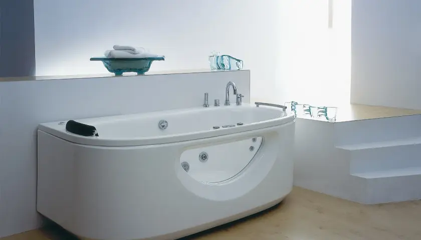Nowoczesna wanna z hydromasażem w łazience z jasnymi płytkami i drewnianą podłogą.