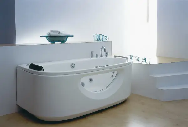 Nowoczesna wanna z hydromasażem w łazience z jasnymi płytkami i drewnianą podłogą.